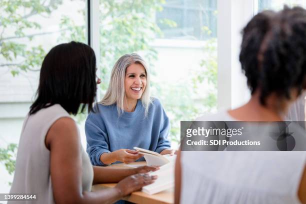group leader helps facilitate the discussion - book club meeting stock pictures, royalty-free photos & images
