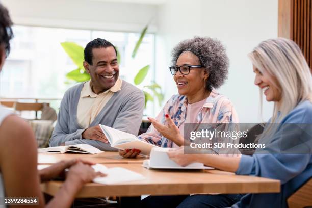 un membre du groupe discute de sa critique du livre - society photos et images de collection