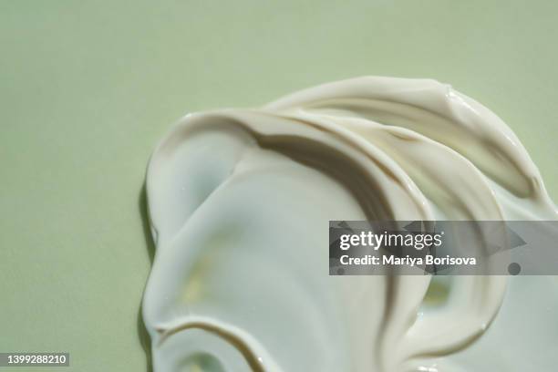 the texture of the cream on a green natural background. - cremes stock pictures, royalty-free photos & images