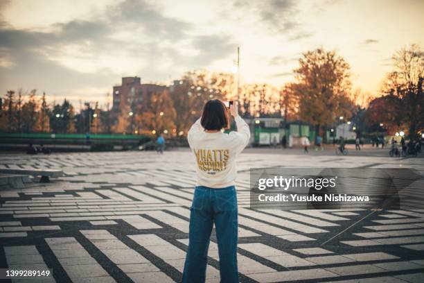 girl with smart phone,in the park - rear view photos - fotografias e filmes do acervo