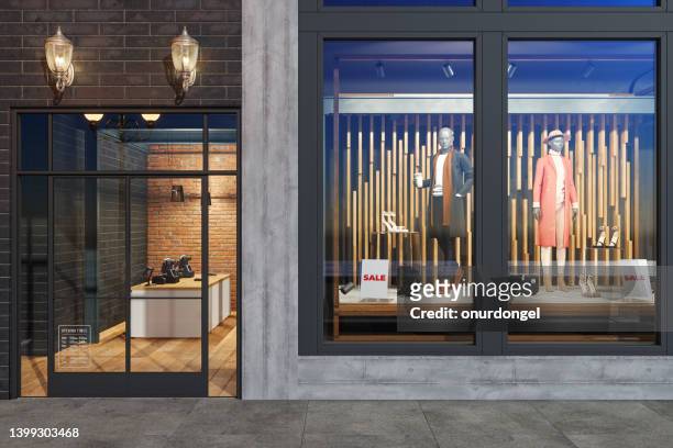 facade of clothing store with mannequins, clothes and shoes displaying in showcase - etalages kijken stockfoto's en -beelden