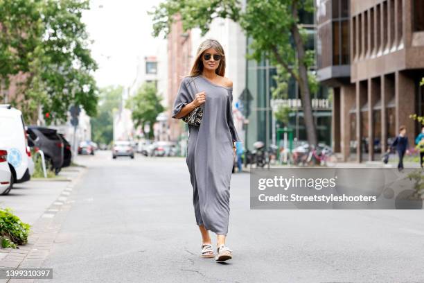 Influencer Gitta Banko wearing a grey maxi t-shirt dress by Cotton Candy, grey sandals by Chanel, a gold lion necklace by Alighieri, a silver watch...