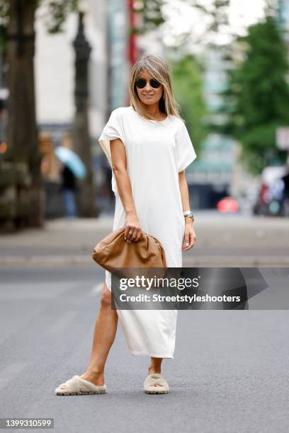 Influencer Gitta Banko wearing a white maxi t-shirt dress with slit by Cotton Candy, cream colored faux fur sandals by Prada, a light brown bag by...