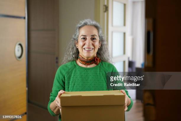 seniorin erhielt paket vom kurier - man opening door woman stock-fotos und bilder
