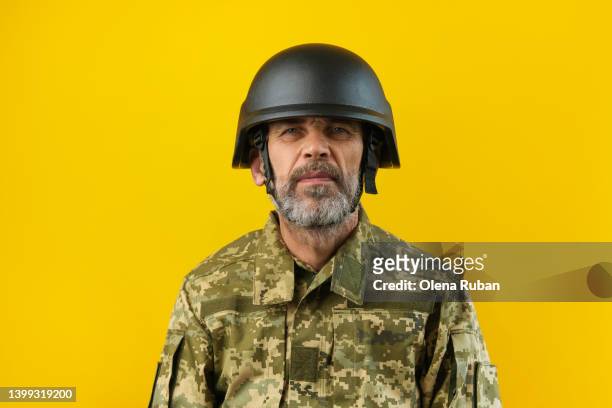 determined mature man in helmet and camouflage. - armadura fotografías e imágenes de stock
