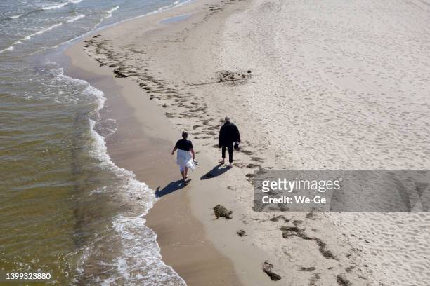 couple âgé marchant sur une belle plage de sable - usedom photos et images de collection