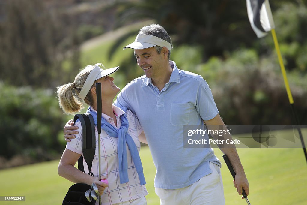 Middle aged couple playing golf