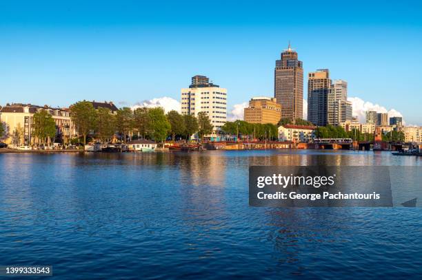 amstel river and tall buildings in amsterdam, holland - amsterdam business stock pictures, royalty-free photos & images