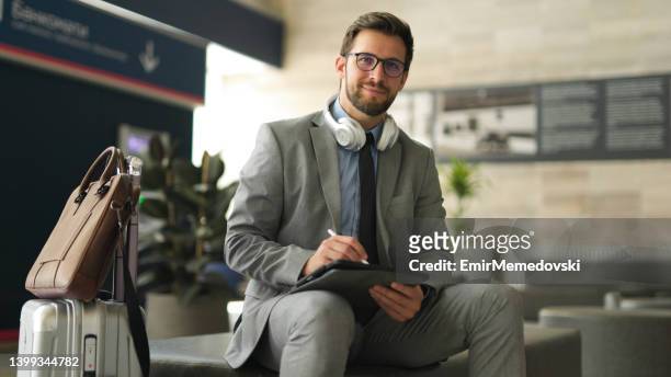 geschäftsmann mit digital-tablette am bahnhof - corporate travel stock-fotos und bilder