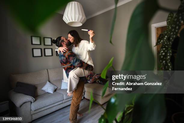 a couple celebrates their positive pregnancy test. - prueba-de-embarazo fotografías e imágenes de stock