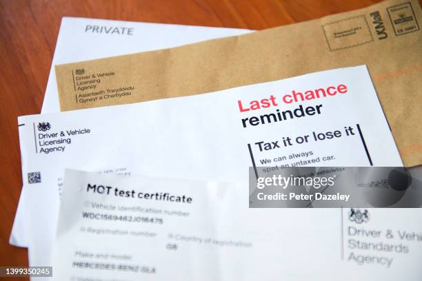 Photo illustration including MOT test certificate, DVLA letter and reminder on a table on May 26, 2022 in London, England.