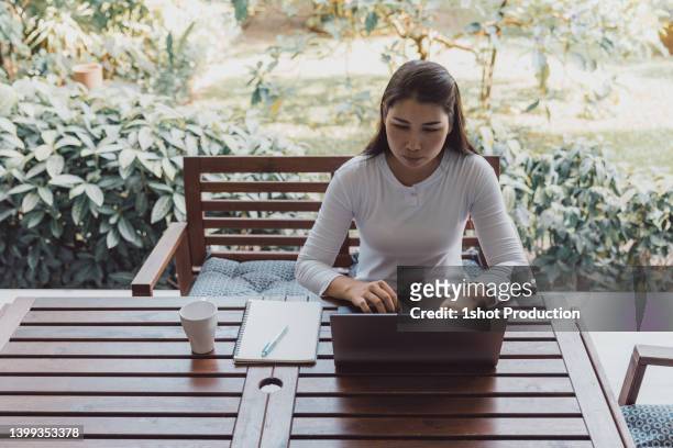 mature woman working at home using latop in balcony. - vpn stock pictures, royalty-free photos & images
