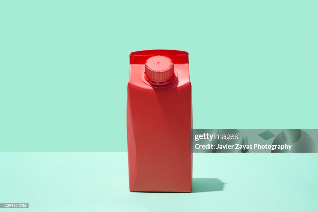 Red Small Milk Or Juice Box On Green Background