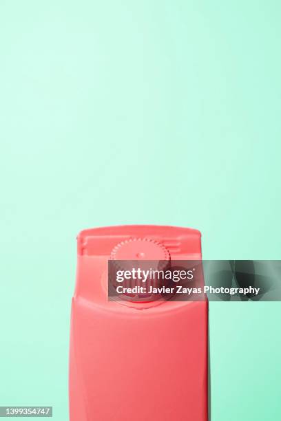 red small milk or juice box on green background - milk carton stock pictures, royalty-free photos & images