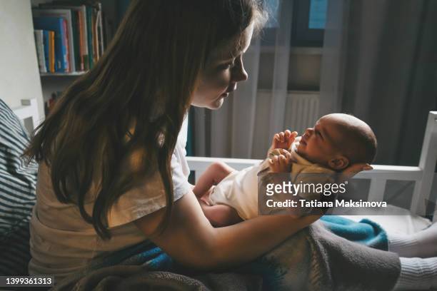 woman and newborn baby in dark room. back lit. - nursery night stock pictures, royalty-free photos & images