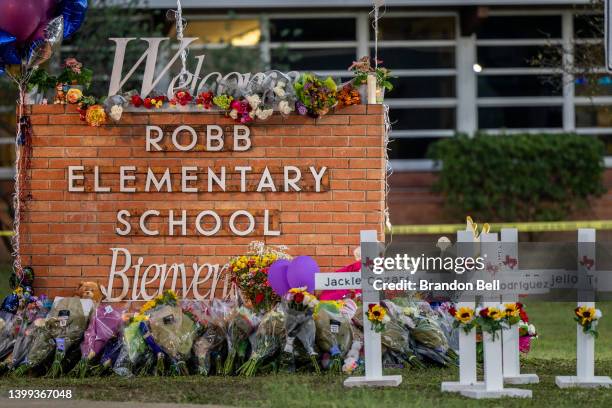 Memorial is seen surrounding the Robb Elementary School sign following the mass shooting at Robb Elementary School on May 26, 2022 in Uvalde, Texas....