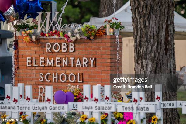 Memorial is seen surrounding the Robb Elementary School sign following the mass shooting at Robb Elementary School on May 26, 2022 in Uvalde, Texas....