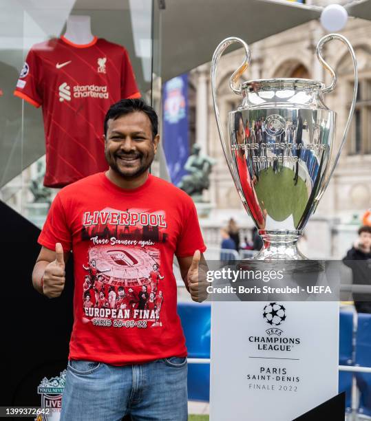 Fans pose with the UEFA Champions League trophy at Hotel de Ville on day 1 of the UEFA Champions League Final 2021/22 Festival ahead of the UEFA...