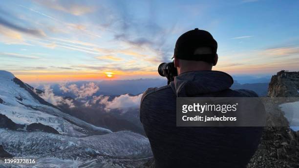 mann, der fotos vom sonnenuntergang macht. europäische alpen - mont blanc sunset stock-fotos und bilder