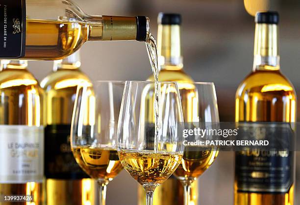 Person serves wine before a tasting session of Chateau Guiraud premier grand cru classe, in its wine estate in Sauternes, southwestern France, on...