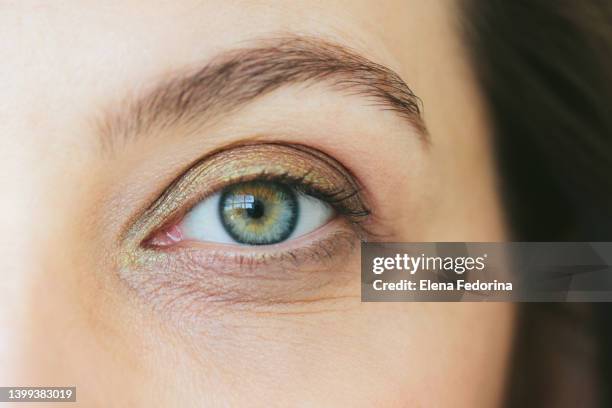 green eye of a woman. - occhi verdi foto e immagini stock