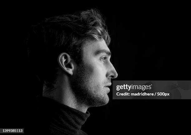 side view of young man against black background,madrid,spain - black and white portrait man stock pictures, royalty-free photos & images