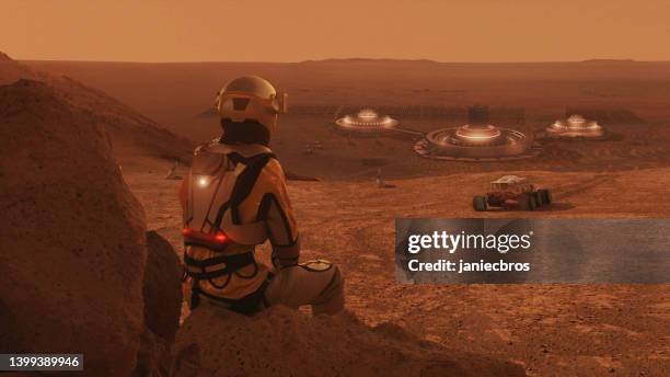 astronaut on planet mars watching a rovers. earth colonization in space - galaxy space explore stock pictures, royalty-free photos & images