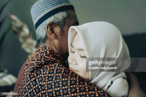 asian young woman hugging her father - ramadan giving stockfoto's en -beelden