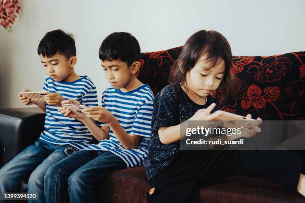 kids playing with modern mobile devices - game three stockfoto's en -beelden