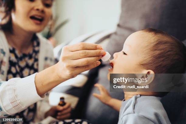 baby receiving oral medicine - vitamin drip stock pictures, royalty-free photos & images