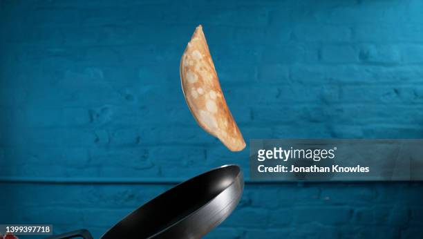 crepe flipping midair over pan - crêpe pancake photos et images de collection