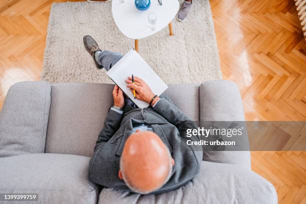 terapeuta sentado en el sofá - psychiatrists couch fotografías e imágenes de stock