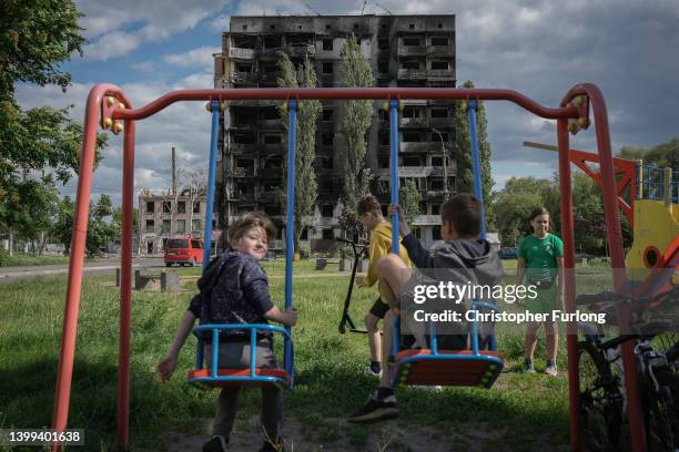 War torn buildings blight the skyline as children play in a park on May 26, 2022 in Borodianka Ukraine. As Russia concentrates its attack on the east...