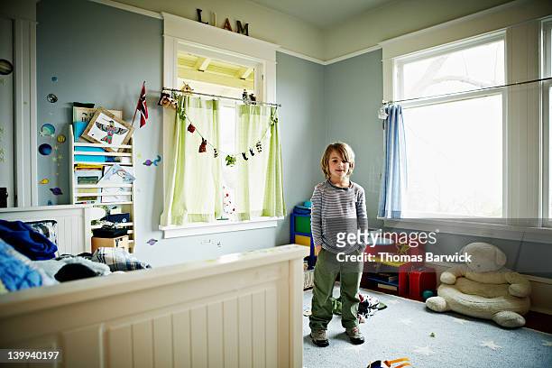 young boy standing in bedroom - boys bedroom stock-fotos und bilder