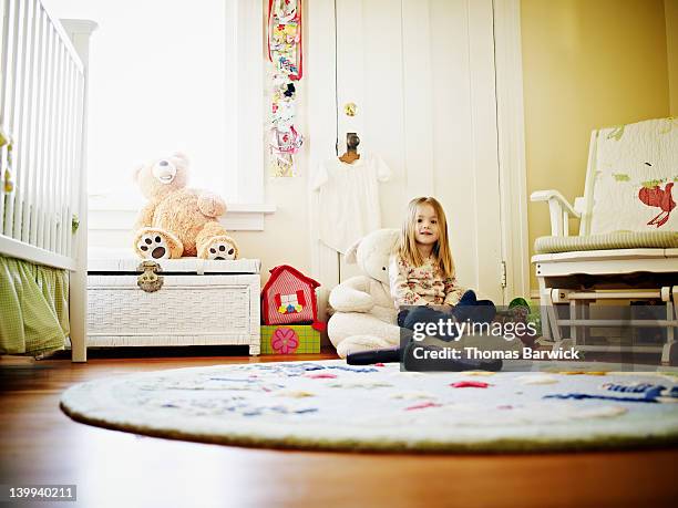 young girl sitting in bedroom smiling - camera bambino foto e immagini stock