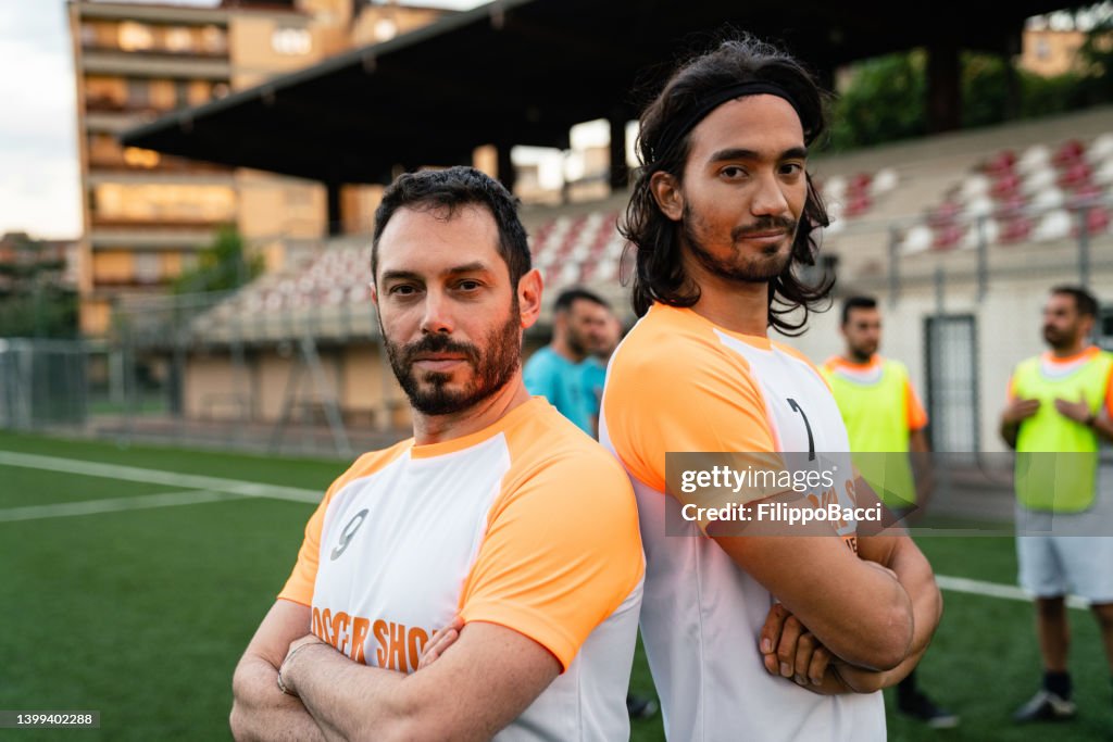 Retrato de dois jogadores de futebol perto das arquibancadas