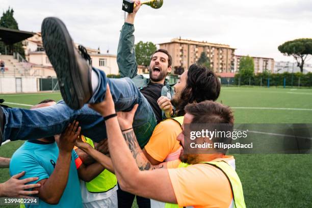 fußballspieler feiern mit ihrem trainer - crowd surfing stock-fotos und bilder