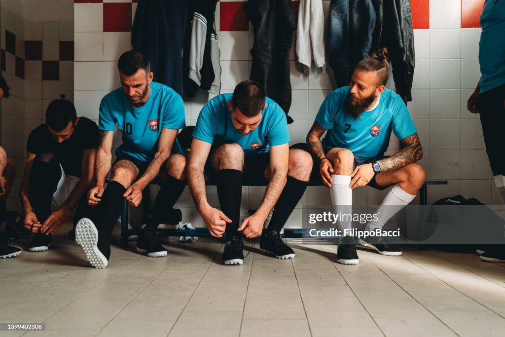 Fußballspieler bereiten sich vor dem Spiel in der Umkleidekabine vor