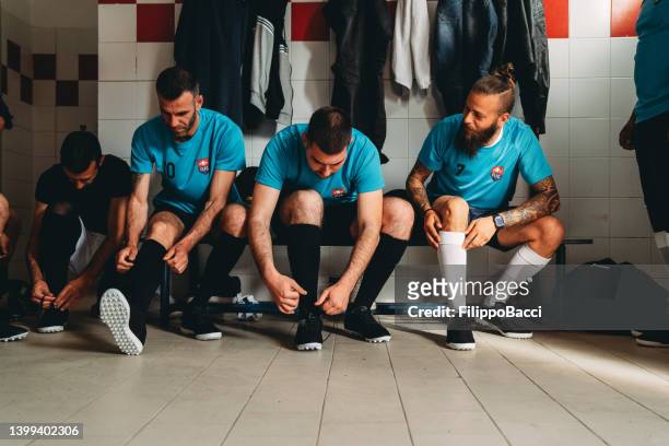 los jugadores del equipo de fútbol se preparan en el vestuario antes del partido - camerino fotografías e imágenes de stock