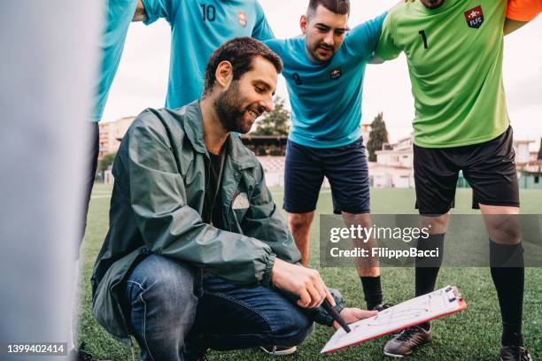 the coach is explaining his tactics to the soccer team - italian football coach stockfoto's en -beelden