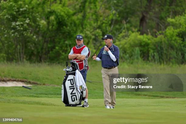 Kevin Sutherland of the United States speaks with his caddie on the first hole during the first round of the Senior PGA Championship presented by...