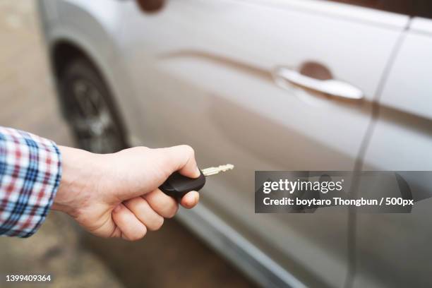 mans hand inserting key into the door lock of a car - car keys hand ストックフォトと画像