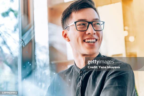 portrait of a young handsome asian entrepreneur, smiling and looking forward to the future innovations - korean culture fotografías e imágenes de stock