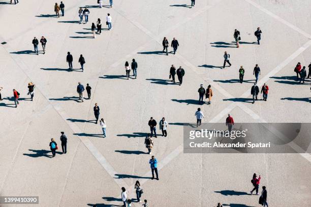 aerial view of large number of people walking on the city square on the sunny day - elevated view stock-fotos und bilder