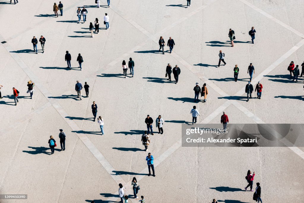 Aerial view of large number of people walking on the city square on the sunny day