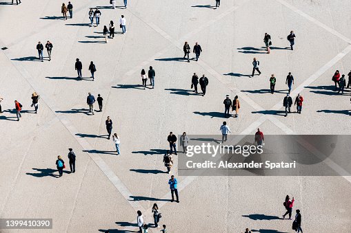 Aerial view of large number of people walking on the city square on the sunny day Aerial view of large number of people walking on the city square on the sunny day