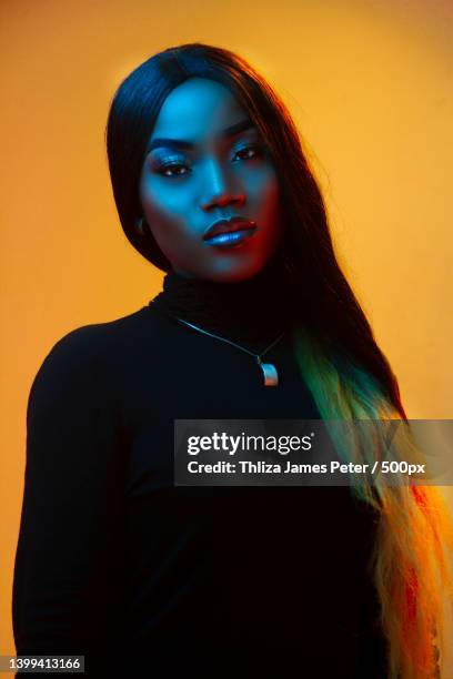 portrait of young woman with dyed hair against yellow background - redactioneel stockfoto's en -beelden