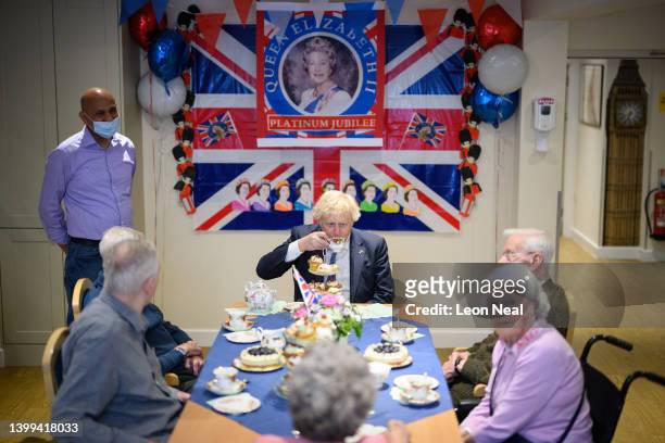 Prime Minister Boris Johnson chats with residents in a Diamond Jubilee-themed room, as he makes a constituency visit to Sweetcroft care home on May...