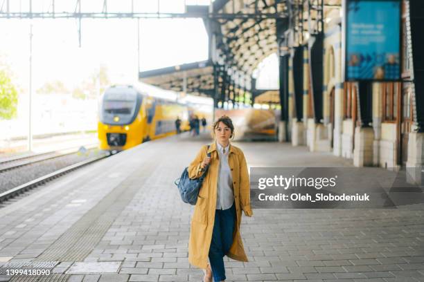 woman waiting for the train on railway station - haarlem netherlands stock pictures, royalty-free photos & images