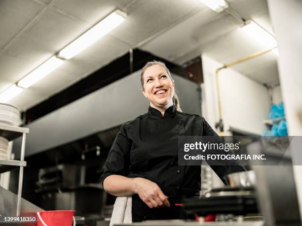 porträt einer köchin in der großküche - gastronomiebetrieb stock-fotos und bilder